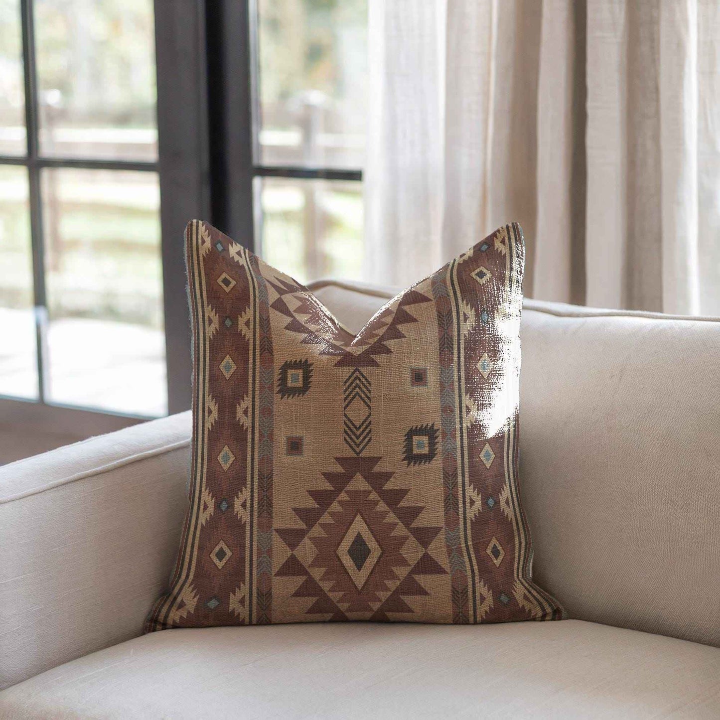 Southwestern throw pillow with geometric pattern styled on a sofa or bed