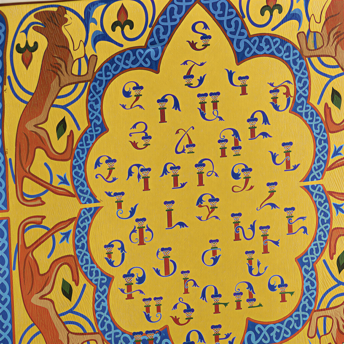 Close view of the Armenian letters inside the yellow scalloped medallion with orange birds
