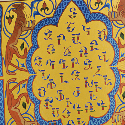 Close view of the Armenian letters inside the yellow scalloped medallion with orange birds