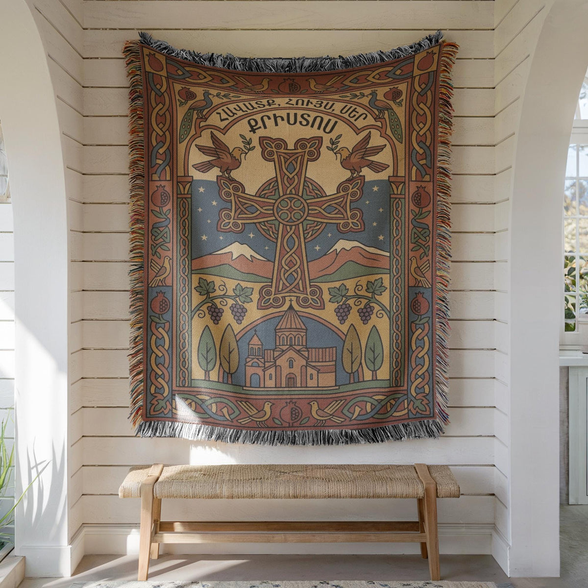 Armenian cross wall tapestry on white shiplap above a wooden bench