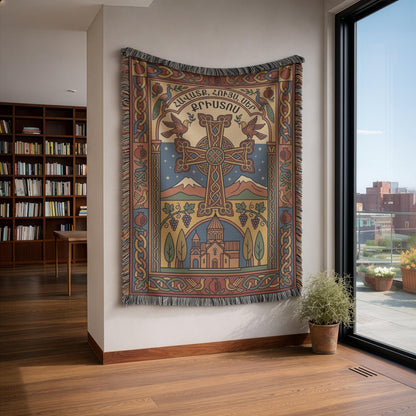 Faith Hope Love Armenian cross tapestry on a white wall beside bookshelves and a tall window