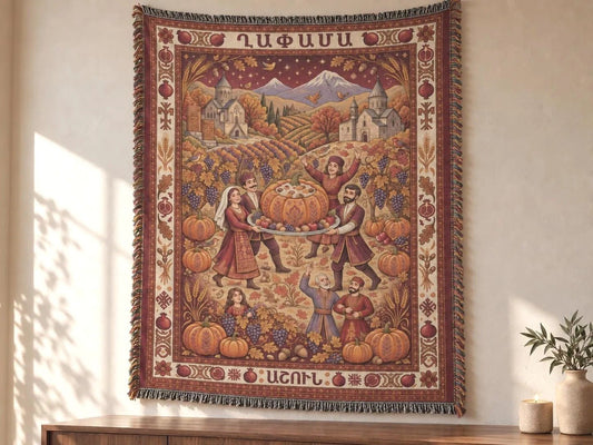 Family Ghapama cotton blanket hanging as a wall tapestry, with pumpkin harvest artwork, mountains, Armenian lettering and decorative fringe.