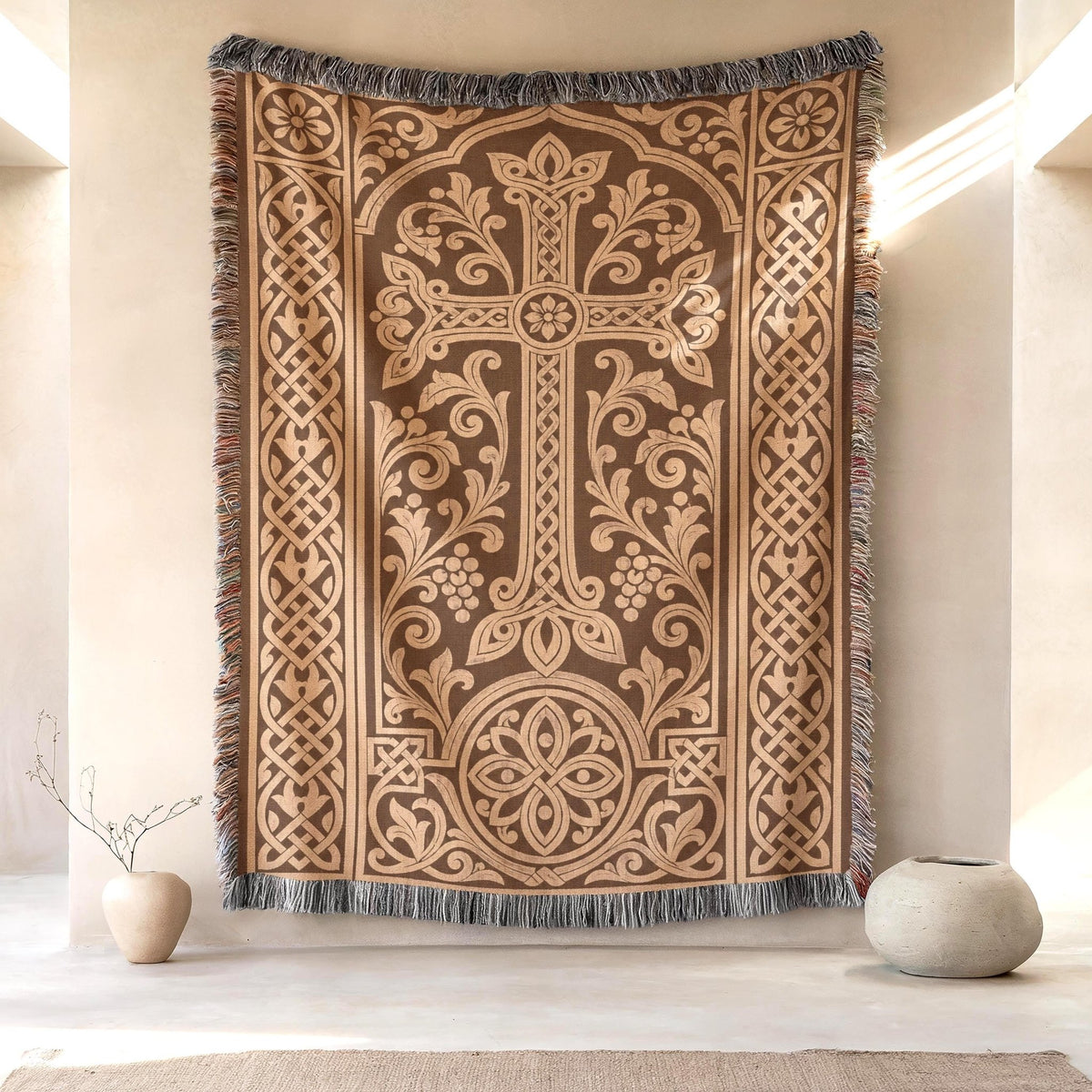 Armenian khachkar woven wall hanging in terracotta and tan, hung on a plaster wall between two stoneware vases