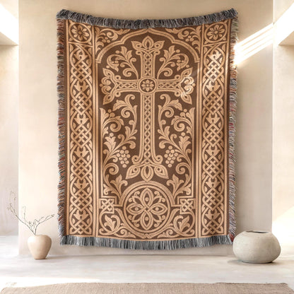 Armenian khachkar woven wall hanging in terracotta and tan, hung on a plaster wall between two stoneware vases