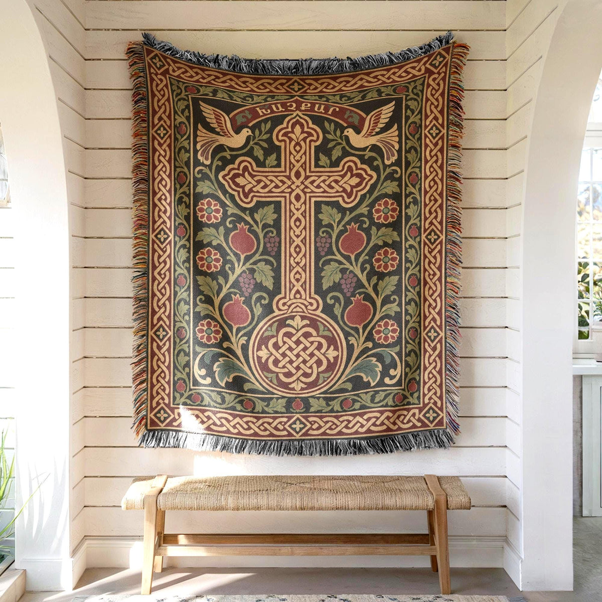 Armenian khachkar wall tapestry hung on white shiplap above a wooden bench