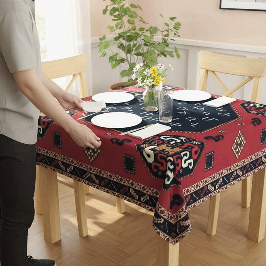 Armenian letters square tablecloth in navy and red on a dining table set with white plates and a vase of flowers