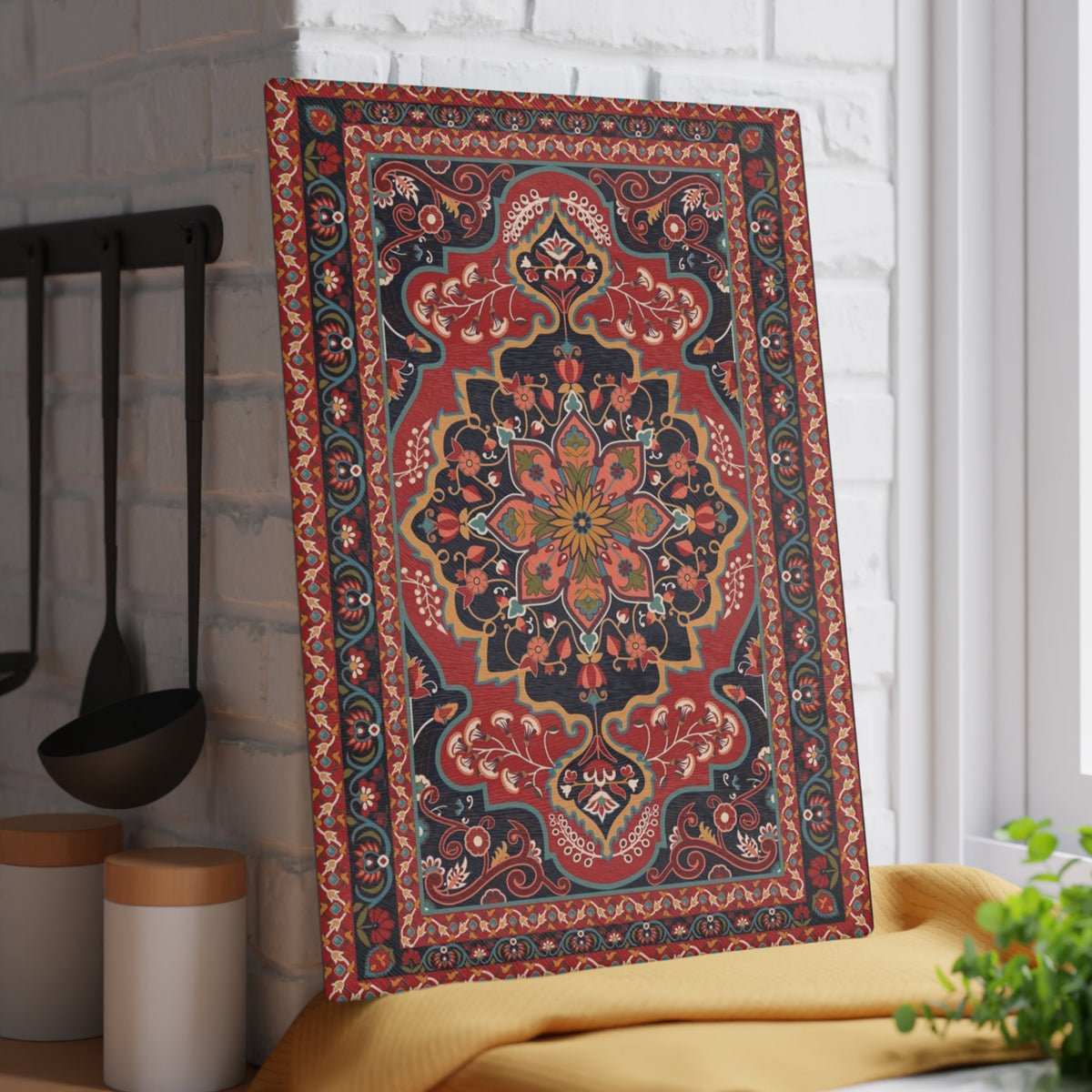 Red and navy Armenian carpet cutting board on a kitchen surface with herbs and stones nearby