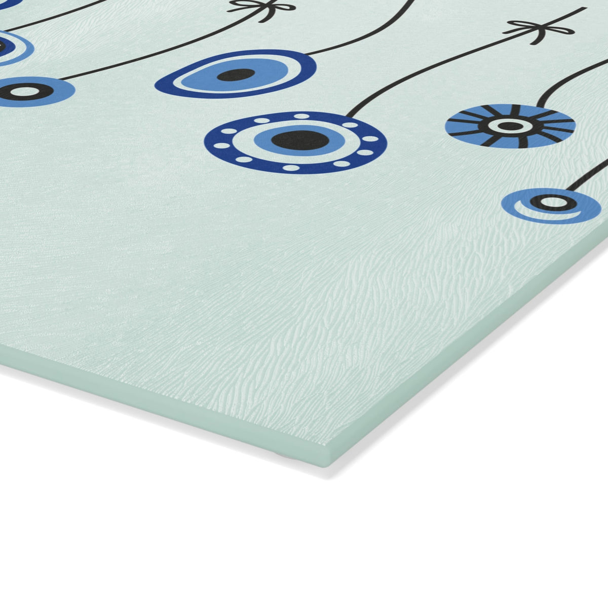 Mint evil eye cutting board with hanging beads seen from above on a kitchen counter