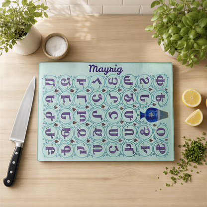 Personalized Armenian alphabet cutting board with the name Mayrig, on a wood counter with a knife and lemons