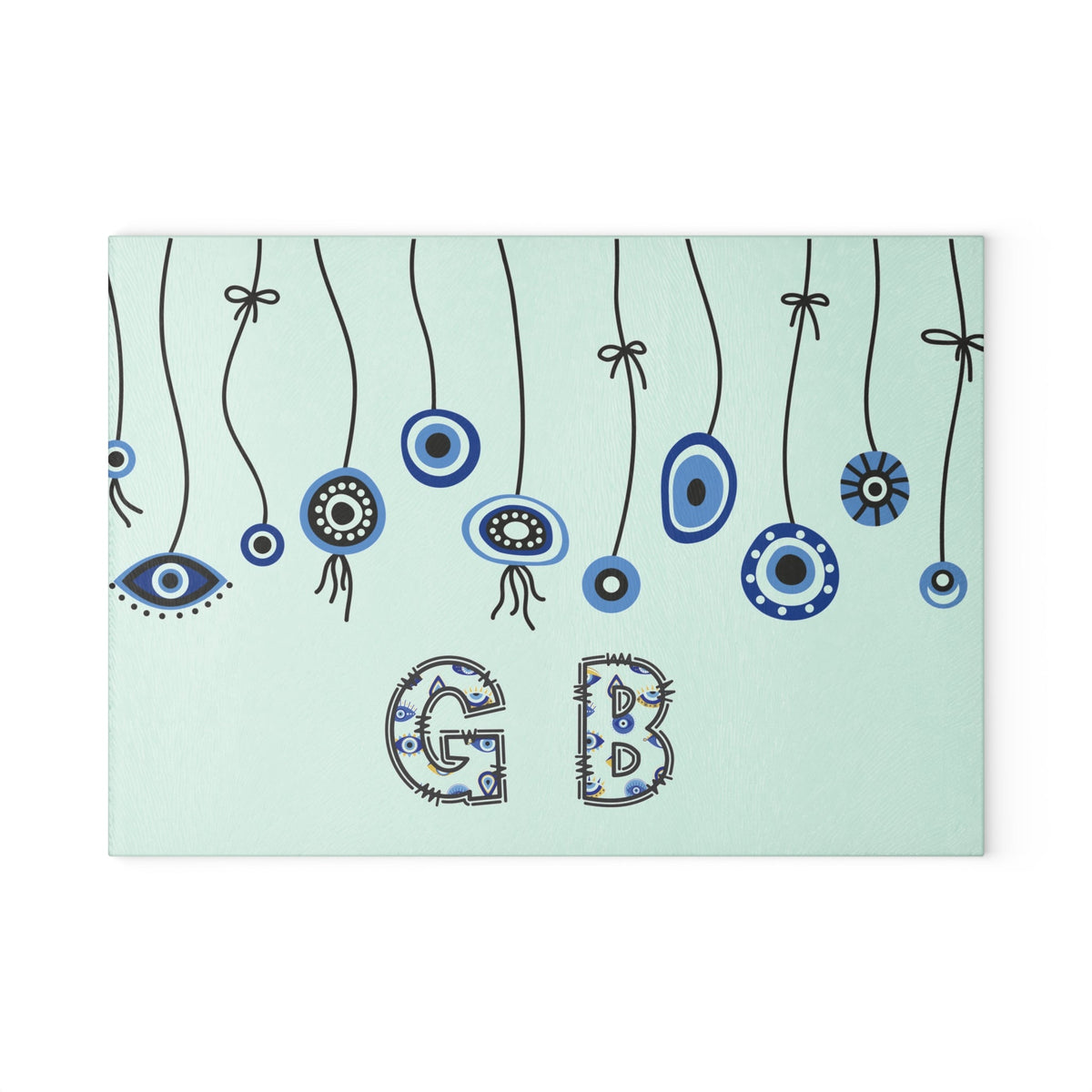 Mint evil eye cutting board with hanging beads on a wooden worktop with a knife alongside