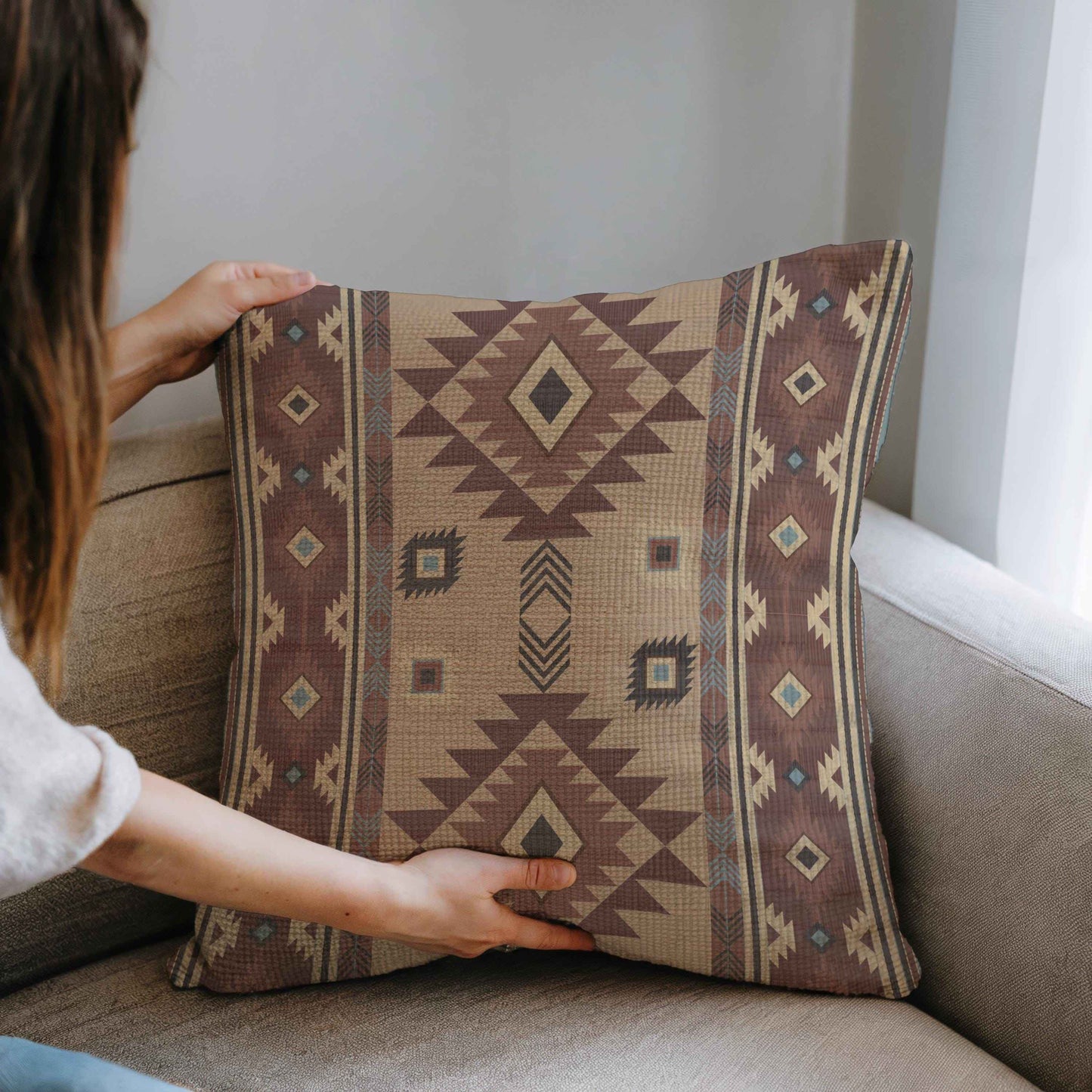 Southwestern throw pillow with geometric pattern styled on a sofa or bed