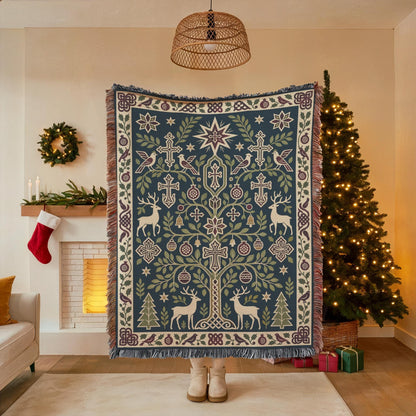 A person stands in front of a large, intricately designed, and colorful blanket with a tree motif, surrounded by Christmas decorations and gifts.