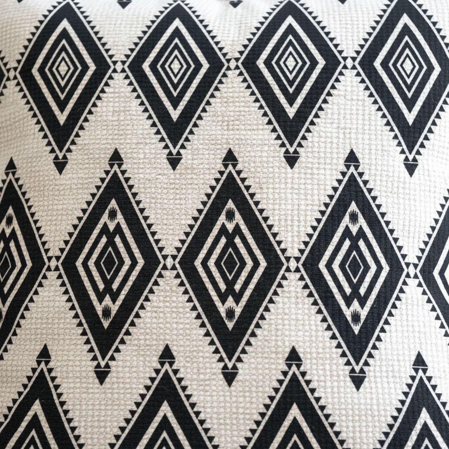 Southwestern throw pillow with geometric pattern styled on a sofa or bed