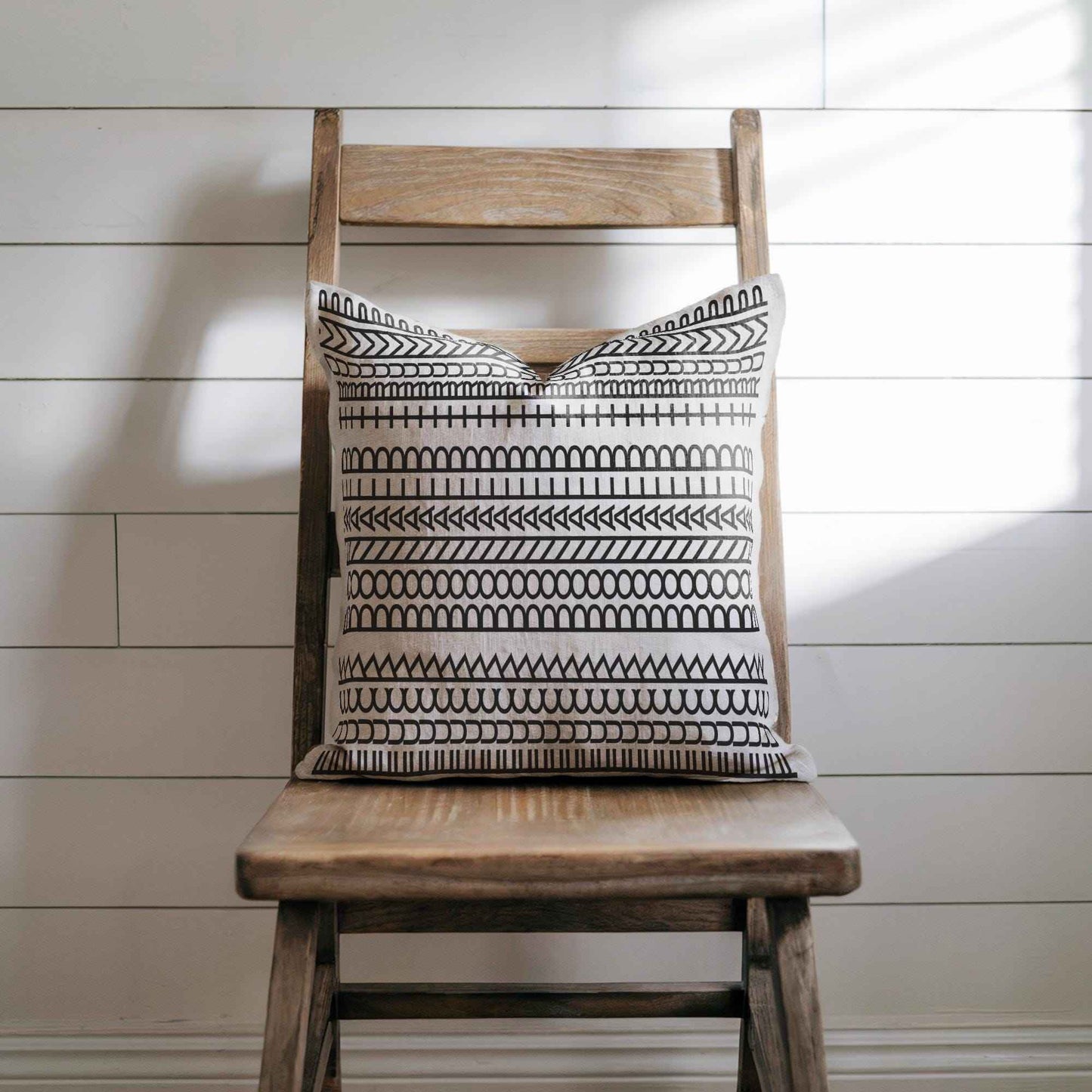 Modern Geometric throw pillow with geometric pattern styled on a sofa or bed