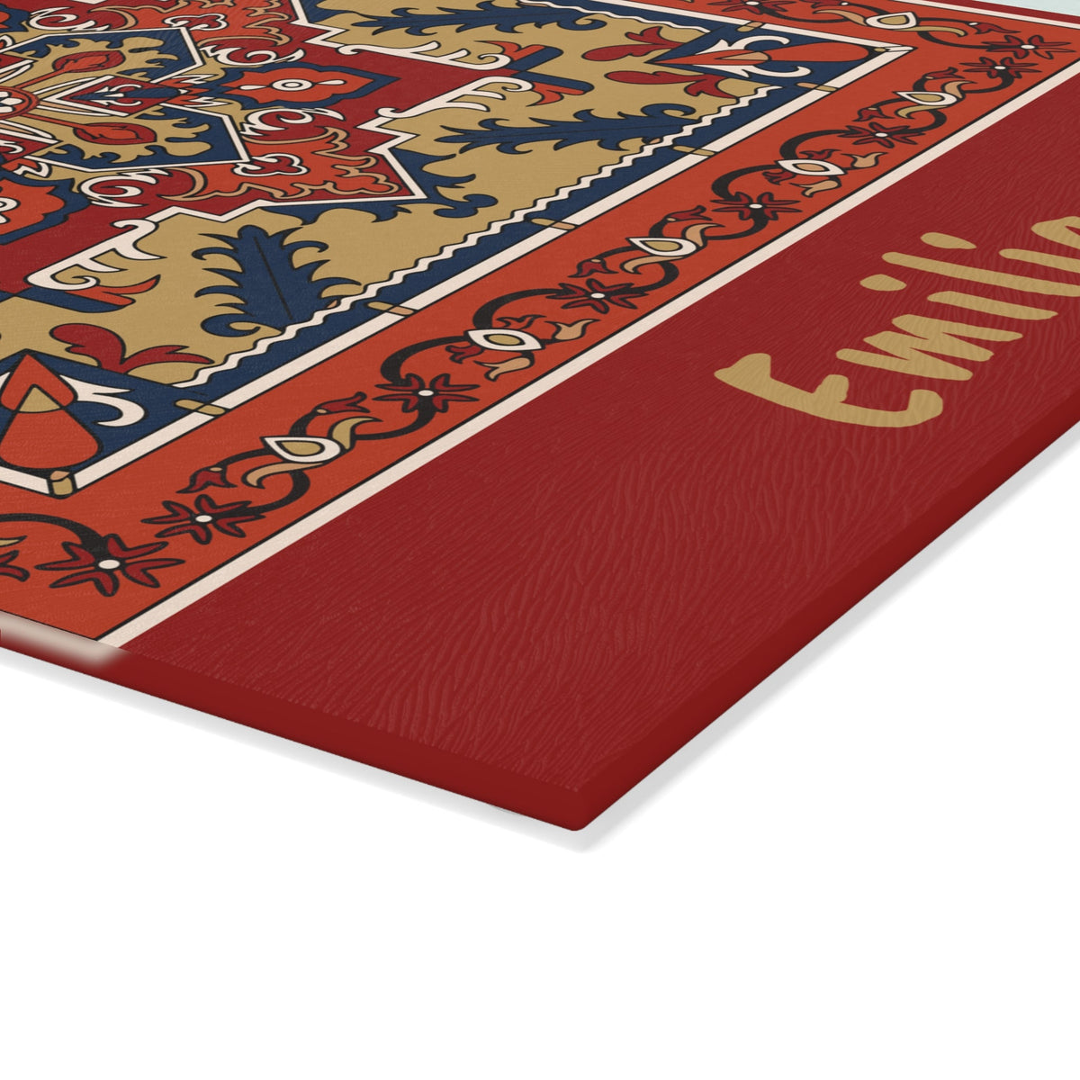 Red Armenian rug cutting board with a gold name on a wooden worktop with a knife alongside