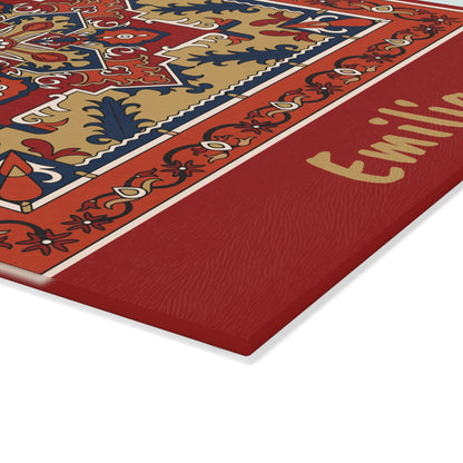 Red Armenian rug cutting board with a gold name on a wooden worktop with a knife alongside