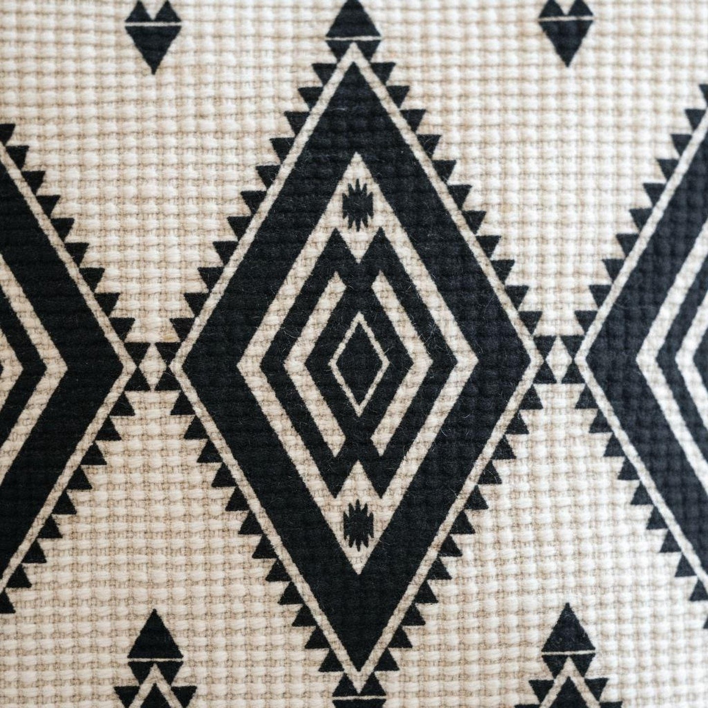 Southwestern throw pillow with geometric pattern styled on a sofa or bed