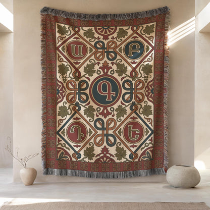 Armenian letter wall tapestry hung above pale ceramic vases on a cream wall