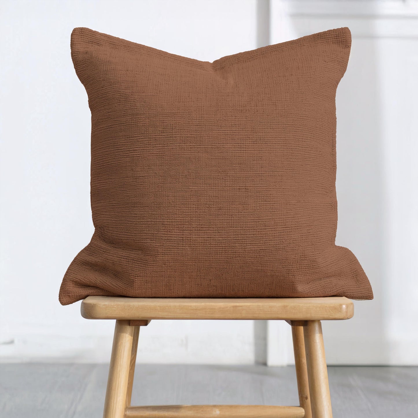 Scandinavian Inspired throw pillow with woven pattern styled on a sofa or bed