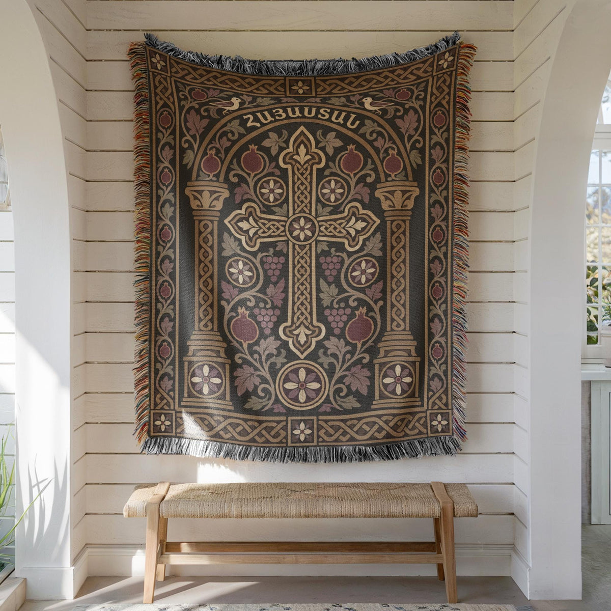 Hayastan khachkar tapestry with doves and columns hung on white shiplap above a wooden bench