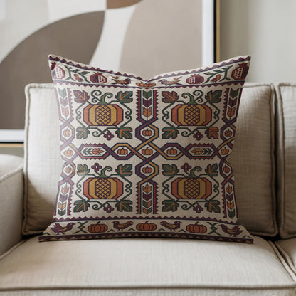 Close view of the cream Ghapama pillow on an armchair, burgundy diamonds and green vines