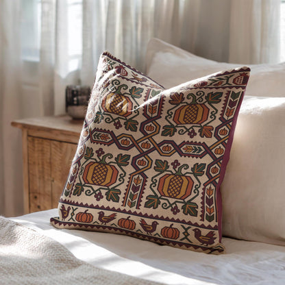 Cream and gold Ghapama pillow on a sofa beside a wooden cabinet and pale curtain