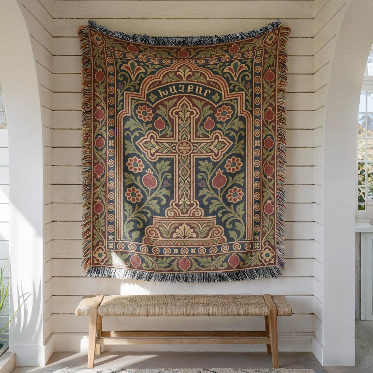 Khachkar cross tapestry in a pointed arch hung on white shiplap above a wooden bench