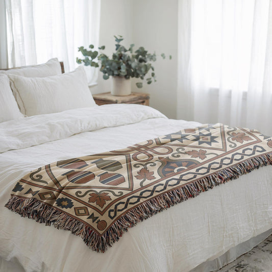 Rust and teal geometric throw folded across a white bed beside a sunlit window